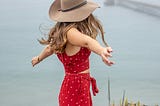 woman in red dress by water for productivity article