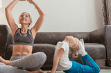 Beautiful baby boomer mum and daughter doing yoga