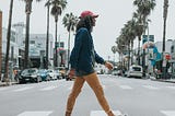 Man walking, instead of driving, across a street
