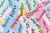 A bunch of pieces of paper with names written on them. The small pieces of paper are pastel colored (blue, green, yellow, pink).