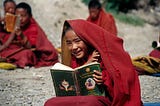 a young boy holding a book in his hand and wearing a cloak over his head Lifestyle With Nina 4 Principles Taught By Buddhist Monks That will transform your life