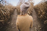 Woman in cornfield, deciding which way to go