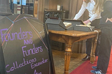 a man and a woman examining books and historical artefacts on a table