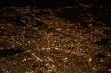 A cityscape at night time with all streets, alleys and roads illuminated