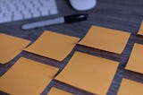 Yellow sticky notes lined up on a desk