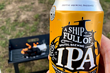 Can of beer in front of a lighted bbq