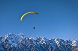 Photo of someone parasailing over mountains