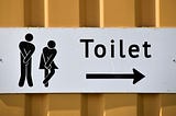 Toilet sign on an orange metal corrugated wall. White sign with black verbage. Symbols of man and woman holding their pee. Arrow pointing to toilets.