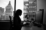 Black and white. Silhouette of a woman at a computer