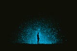 Dark silhouette of a person against a cosmic blue light and black background.