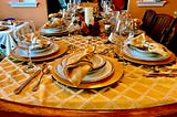 Photo 1. Family gathering, photo by Ken S on Unsplash, showing a table full of plates for a family.