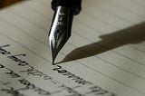 A fountain pen writing in a notepad