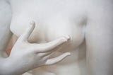 A statue of a woman touching her chest