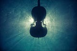 A silhouette of a violin in water; it is backlit by the sun.