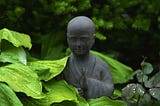 statue of monk among leaves