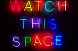 A neon sign that says watch this space