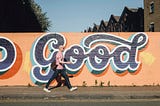 man walking next to graffiti wall