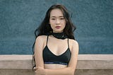 Yuung Japanese woman with bare midrift in halter top and jeans.