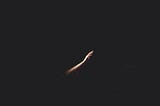 A hand stretching out of the dark, reaching out for the light