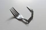 A fork with a linked decorative chain for a handle. Completely useless. Another art piece from Katerina Kamprani to symbolize the danger of a broken user experience.