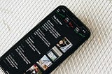Photograph of smartphone with news items on screen