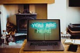 Open laptop on a desk with the words “You are here” on the screen