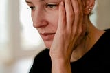 A woman looking down, staring into space.