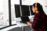 Girl with headphones working at a computer.