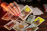 A woman’s hand picking up a tarot card.