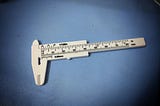 A white plastic Vernier caliper