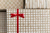 Gift-wrapped spotted package tied with a red ribbon