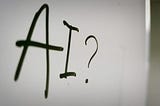 AI? written in black marker pen on a whiteboard.