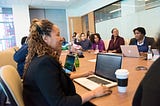 Adult professionals sitting around a conference table