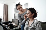 Beautiful woman being made up by her ‘servant’