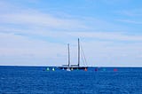 A photo of a boat with furled sails in a sunny day, in the Mediterranean Sea.
