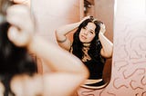 Girl primping herself in front of a mirror