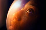 A futuristic close-up of a person in a space helmet, gazing into the distance with reflections of light, symbolizing the exploration of AI Autonomy and its role in Digital Transformation Strategies and Business Growth.