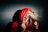 Girl in a hooded sweatshirt screaming.