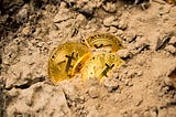 Bitcoin “coins” uncovered from dirt. A metaphor for “mining” bitcoin.