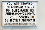 a sign that that has english, russian, and german words on it