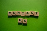 green background with the letters spelling out, “contact us” on individual blocks
