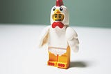 a plastic Lego man in a chicken suit