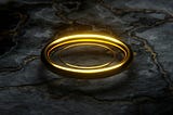a gold ring on black marble
