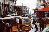 Busy street in downtown Lagos island with yellow keke NAPEPs and pedestrians