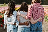 A mixed group of people looking over the beautiful field. It is tied into the topic of dating in modern changing times.