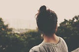 A woman stands with her back to the camera.