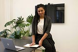 A woman smiling in an office environment, feeling grateful for her employment.