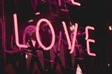 Neon pink sign saying LOVE.