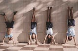 2 boys and 2 girls handstand against a wall.