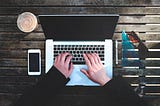 Top down view of a person working on a laptop.